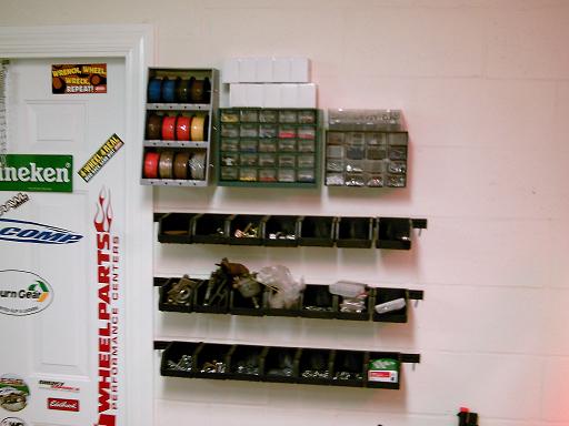 Door with stickers and shelves of parts bins on wall