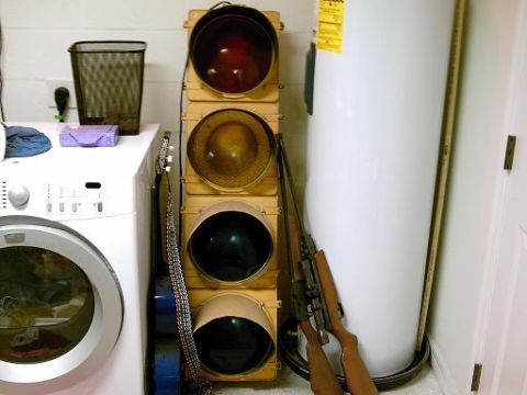 1986 Ford Bronco - A collection of items including a traffic signal, firearms, and a guitar are stored next to a washing machine and water heater.