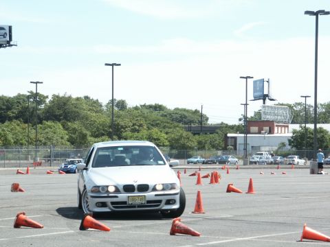 2001 Mercury Grand Marquis - A white 2001 BMW 5 Series navigates a cone-filled autocross course on a sunny day.