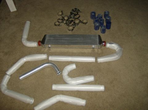 1996 Ford Probe - Intercooler and piping kit laid out on a carpeted surface with various clamps and couplers.