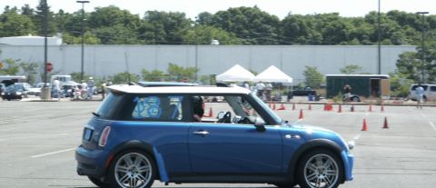 2001 Mercury Grand Marquis - A blue Mini Cooper is parked in a lot with orange cones set up for an event.