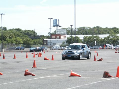 2001 Mercury Grand Marquis - A silver Mini Cooper navigates a course marked by orange traffic cones on a sunny day.