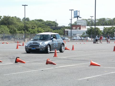 2001 Mercury Grand Marquis - A silver Mini Cooper with a white roof and the number 219 on its door navigates an autocross course marked by orange cones.