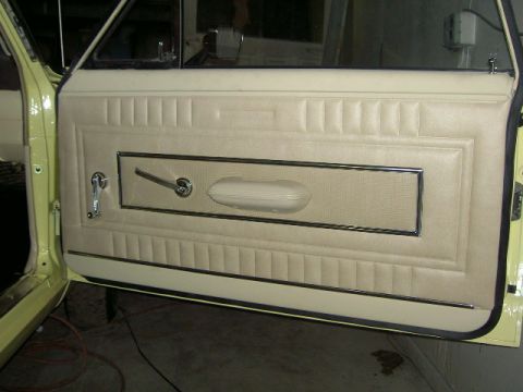 1967 Ford Ranchero - Interior view of a 1967 Ford Ranchero's beige door panel with chrome accents.