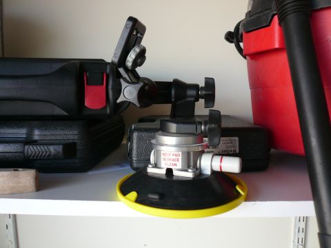 1996 Ford Probe - A suction cup mount is placed on a shelf with tool cases and a red shop vacuum cleaner in the background.