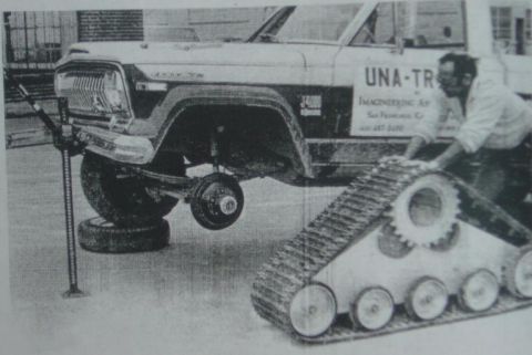 2000 Ford E350 - A man works on a tracked vehicle beside a lifted Jeep Wagoneer.