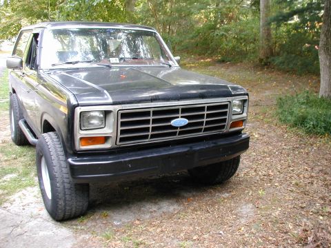 1986 Ford Bronco - Front view of a black Ford Bronco from the early 1980s, showing its grille and headlights.