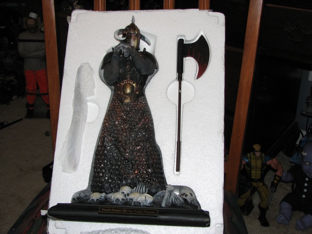 Death Dealer III statue with axe, in packaging. Other figures visible in background