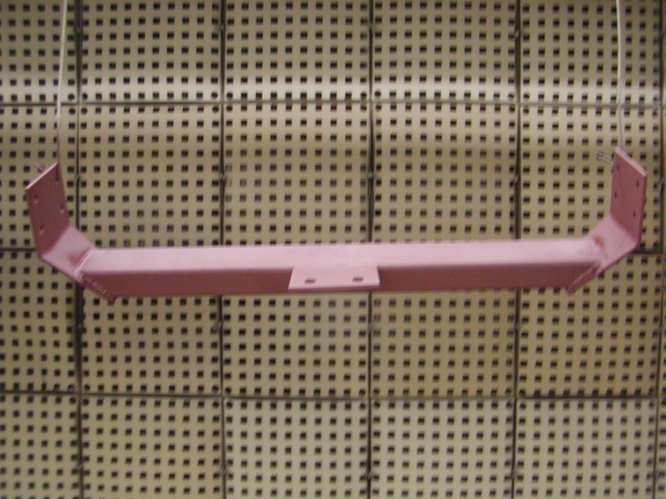 Painted metal crossmember hanging against a grid background