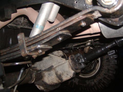 1991 Ford Bronco - Underside view of a vehicle's suspension system, including leaf springs and a shock absorber.