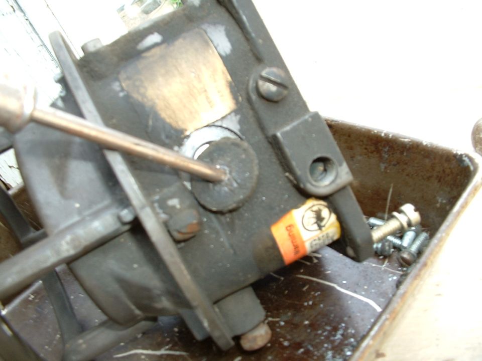 Carburetor with screwdriver, orange label with text