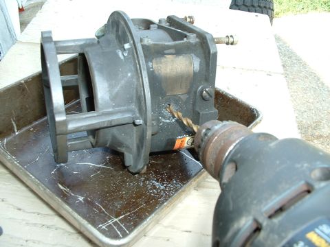1978 Ford Bronco - Drilling into a carburetor, possibly for modification or repair.