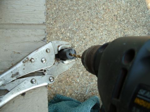 1978 Ford Bronco - A close-up shows a drill bit boring into a small cylindrical object secured by locking pliers.