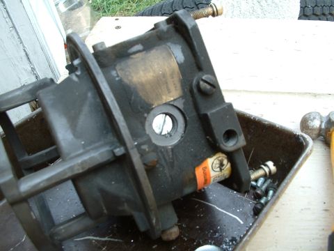 1978 Ford Bronco - A close-up view of a carburetor, showing an orange warning sticker and surrounding hardware.