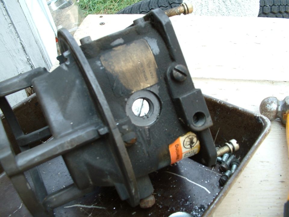 Carburetor with orange warning sticker and visible screws