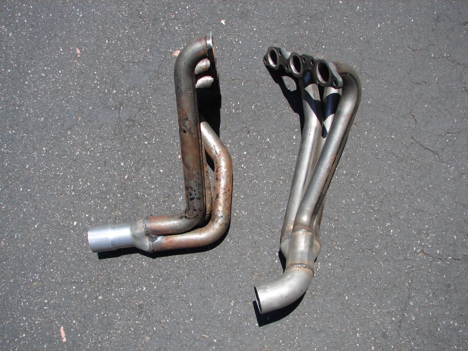 Pair of three-into-one stainless V6 tubular exhaust headers on asphalt