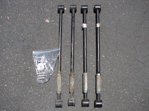 1992 Ford Taurus - Set of four suspension control arms with hardware, displayed on a paved surface.