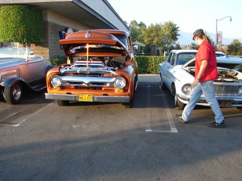 1992 Ford Taurus - Two classic vehicles are parked side-by-side with their hoods up, displaying their engines.
