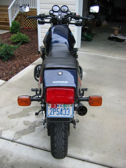 1985 Ford LTD Crown Victoria - Rear view of a dark blue Suzuki motorcycle with a North Carolina license plate.