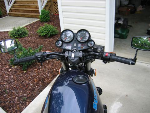 1985 Ford LTD Crown Victoria - View of motorcycle handlebars, gauges, and part of the fuel tank, parked outdoors.