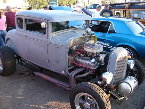 1992 Ford Taurus - A custom hot rod coupe is shown with its engine and exhaust pipes visible, alongside other vehicles.