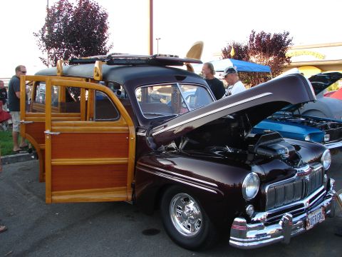 1992 Ford Taurus - A classic woodie station wagon with its hood and doors open is displayed at an outdoor event.