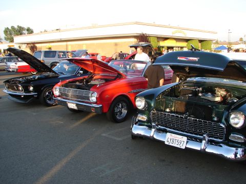 1992 Ford Taurus - Three classic American cars, a 1955 Chevrolet, a Ford Falcon, and a Ford Mustang, are displayed with their hoods up.