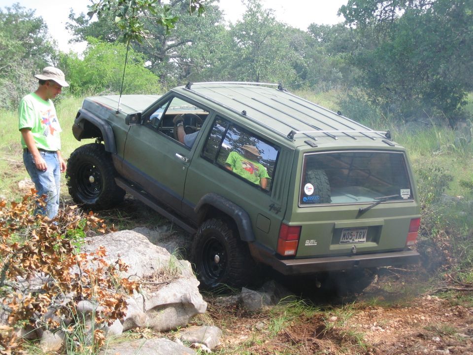 Green Jeep Cherokee XJ off-roading, rear view. License plate K05-TRV