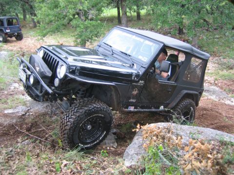 2001 Jeep Wrangler - A black 2001 Jeep Wrangler navigates a rocky trail with another Jeep in the background.