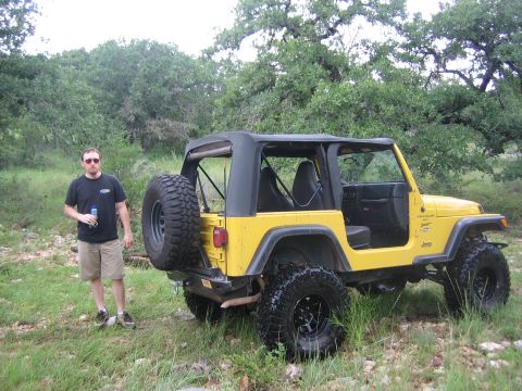2001 Jeep Wrangler - A yellow 2001 Jeep Wrangler is parked outdoors with a man standing beside it.