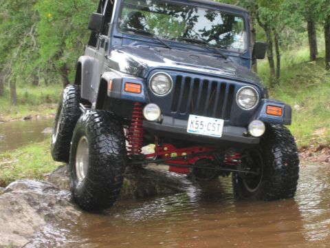 2001 Jeep Wrangler - This blue 2001 Jeep Wrangler navigates through a shallow stream, its off-road capabilities.