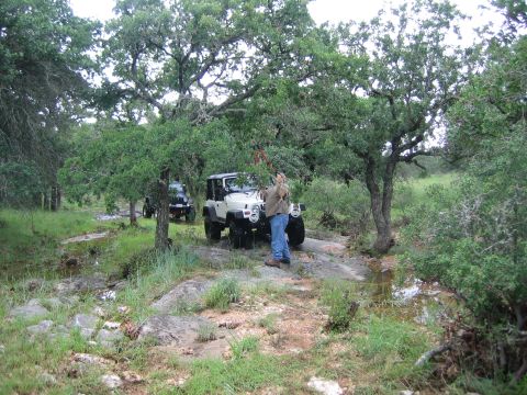 2001 Jeep Wrangler - Two Jeep Wranglers are parked off-road on a rocky path surrounded by trees and vegetation.