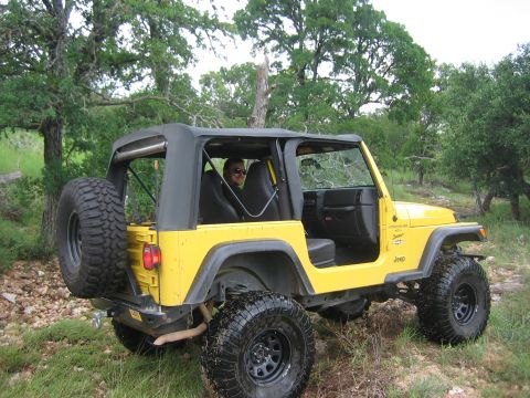 2001 Jeep Wrangler - A yellow 2001 Jeep Wrangler is shown parked off-road with its doors removed.