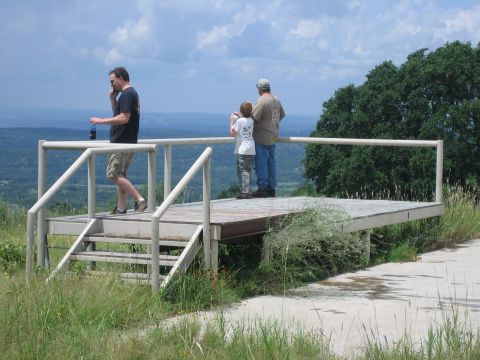 2001 Jeep Wrangler - Three people stand on an elevated platform, enjoying a scenic view of the landscape below under a cloudy sky.