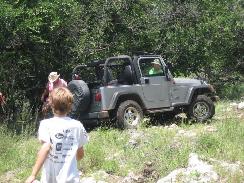 2001 Jeep Wrangler - A silver Jeep Wrangler is parked on a rocky trail surrounded by trees, with people nearby.