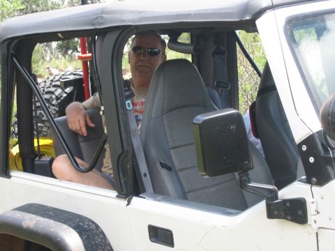 2001 Jeep Wrangler - Man wearing sunglasses sits in the driver's seat of a white Jeep Wrangler.