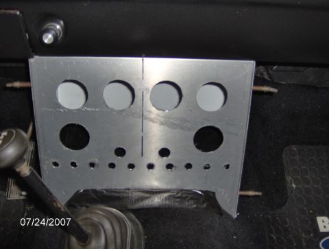 1978 Ford Bronco - A custom aluminum panel with various circular cutouts is installed in the interior of a vehicle, near the gear shifter.