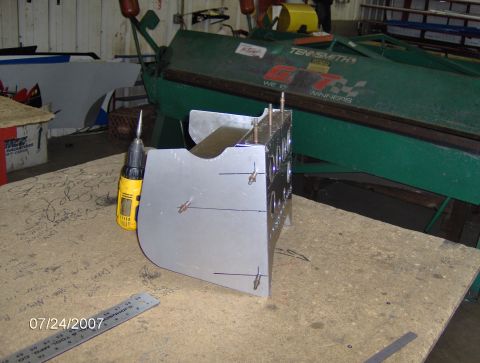 1978 Ford Bronco - A metal component is shown on a workbench, with tools and a ruler nearby, suggesting a fabrication or repair process.