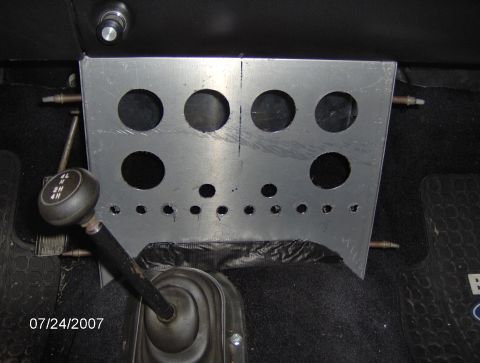 1978 Ford Bronco - A close-up view of a vehicle's interior, focusing on the shifter and a custom-made metal plate.