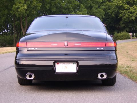 1996 Mercury Grand Marquis - Rear view of a black Lincoln Mark VIII, showing its distinctive taillight bar and dual exhaust.
