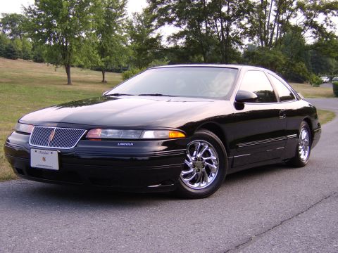 1996 Mercury Grand Marquis - A black Lincoln Mark VIII coupe is shown from a three-quarter front view on a paved road.