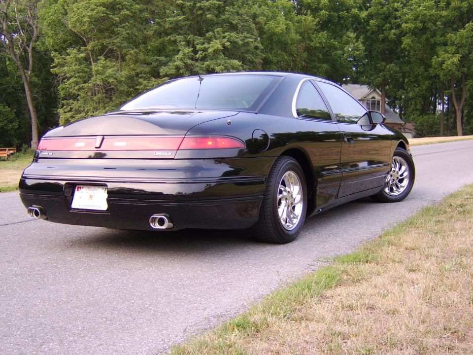 Black Lincoln Mark VIII coupe rear three-quarter view on roadside
