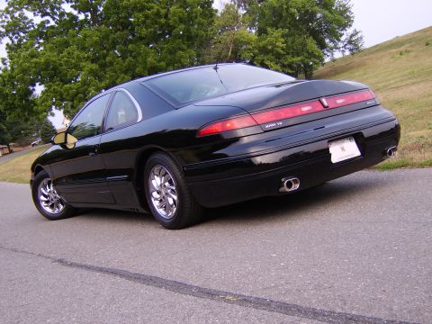 1996 Mercury Grand Marquis - Rear view of a black coupe with chrome wheels and dual exhaust pipes.