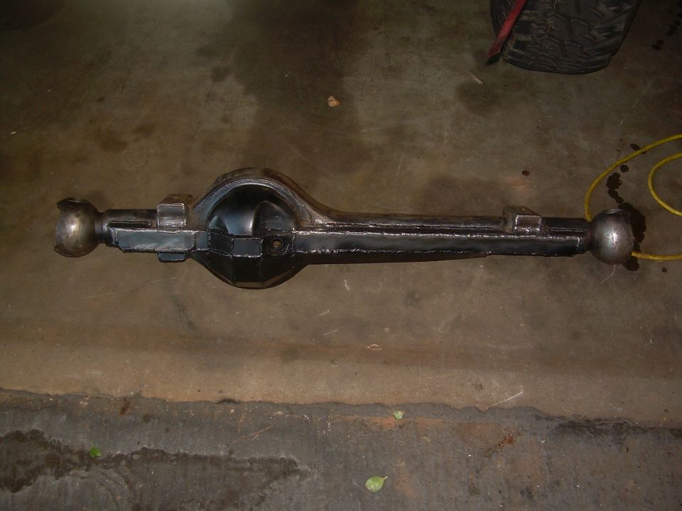Rear axle assembly on a concrete floor. A yellow cord is nearby