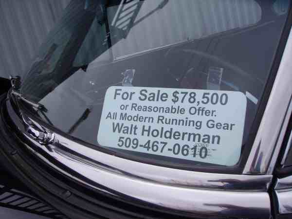 Windshield of a car with a 'For Sale $78,500' sign, including contact info