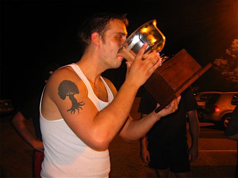 1985 Ford LTD Crown Victoria - A man celebrates with a trophy while two cars are visible in the background at night.