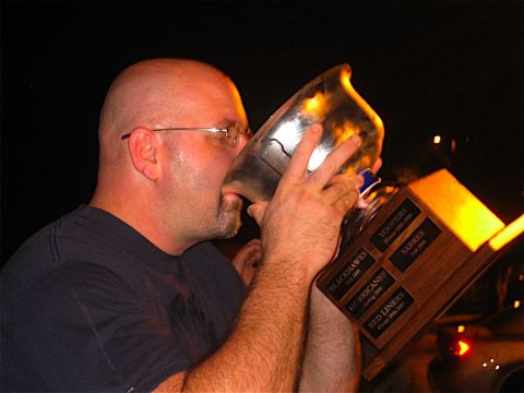 1985 Ford LTD Crown Victoria - Man celebrates with a trophy, which has team names like Blackhawks and Hurricanes engraved on it.