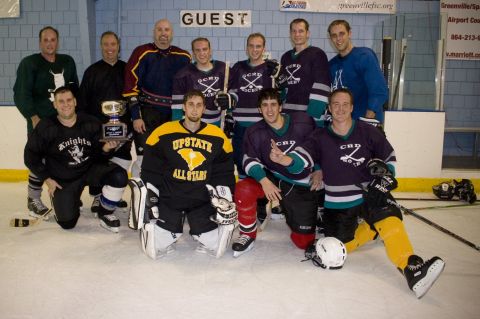 1985 Ford LTD Crown Victoria - A hockey team poses for a photo on the ice, holding a championship trophy.
