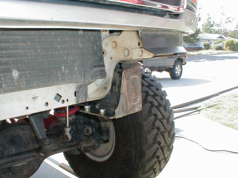 1996 Ford Bronco - The photo shows a close-up of a vehicle's front bumper mounting bracket and a large off-road tire.