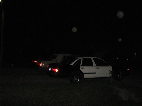 1988 Mercury Grand Marquis - A two-tone black and white 1988 Mercury Grand Marquis is parked at night alongside another vehicle.